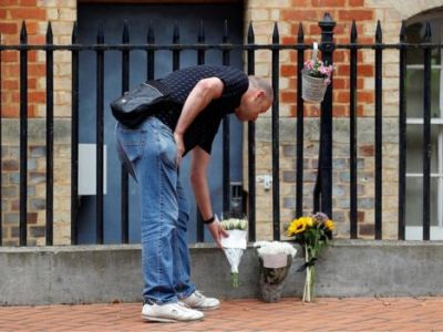 Мужчина кладет цветы возле входа в парк, где погибли три человека. Фото: REUTERS